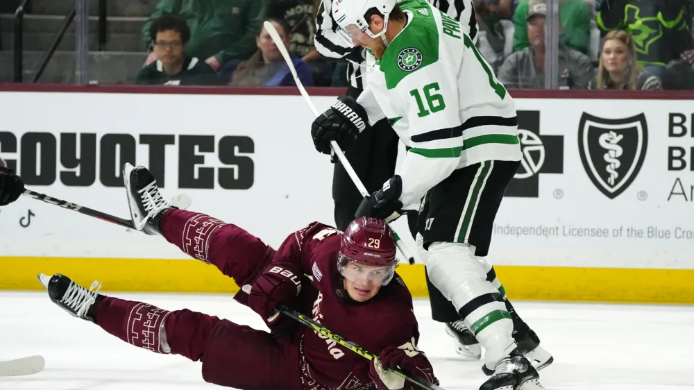Dallas Stars center Joe Pavelski (16) sends Arizona Coyotes center Barrett Hayton (29) to the ice during the third period of an NHL hockey game Friday, March 31, 2023, in Tempe, Ariz. The Stars won 5-2. (AP Photo/Ross D. Franklin)