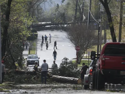 People work to clear trees on the road in Cammack Village, Ark., after a tornado swept through the area, Friday, March 31, 2023. (Stephen Swofford/Arkansas Democrat-Gazette via AP)