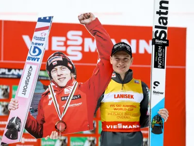 Anže Lani&scaron;ek je na zmagovalni oder v skupnem se&scaron;tevku svetovnega pokala pri&scaron;el s kartonskim portretom Dawida Kubackega, ki se zaradi težav z ženinim zdravjem na koncu sezone ni boril za skupno drugo in tretje mesto. Foto: Luka Cjuha