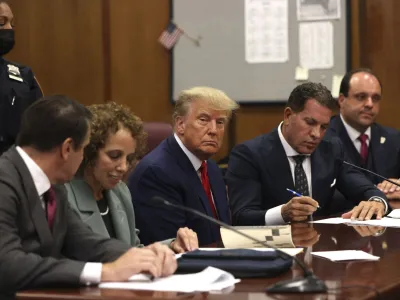 Former U.S. President Donald Trump (c) appears in court with his legal team for an arraignment on charges stemming from his indictment by a Manhattan grand jury following a probe into hush money paid to porn star Stormy Daniels, in New York City, U.S., April 4, 2023. REUTERS/Andrew Kelly/Pool