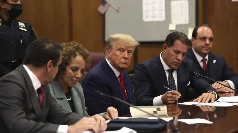 Former U.S. President Donald Trump (c) appears in court with his legal team for an arraignment on charges stemming from his indictment by a Manhattan grand jury following a probe into hush money paid to porn star Stormy Daniels, in New York City, U.S., April 4, 2023. REUTERS/Andrew Kelly/Pool