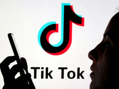 FILE PHOTO: A person holds a smartphone as Tik Tok logo is displayed behind in this picture illustration taken November 7, 2019. Picture taken November 7, 2019. REUTERS/Dado Ruvic/Illustration/File Photo