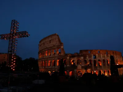 A cross is lit up for the Via Crucis (Way of the Cross) procession, which Pope Francis is to follow from Casa Santa Marta at the Vatican due to the intense cold, as part of Good Friday celebrations at the Colosseum, in Rome, Italy April 7, 2023. REUTERS/Remo Casilli