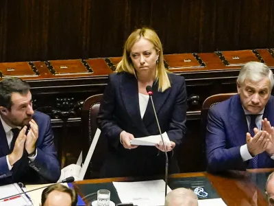 Italian Premier Giorgia Meloni, center, addresses the lower Chamber ahead of a confidence vote for her Cabinet, Tuesday, Oct. 25, 2022. Giorgia Meloni, whose party with neo-fascist roots finished first in recent elections, is Italy's first far-right premier since the end of World War II. She is also the first woman to serve as Italian premier. At left is Infrastructures Minister Matteo Salvini, and at right, Foreign Minister Antonio Tajani. (AP Photo/Alessandra Tarantino)