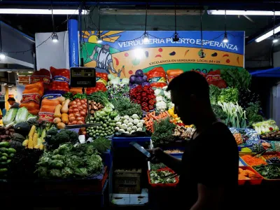 FILE PHOTO: A costumer walks past a greengrocery store, as Argentina's annual inflation rate tore past 100% in February, the country's statistics agency said on Tuesday, the first time it has hit triple figures since a period of hyperinflation in 1991, over three decades ago, in Buenos Aires, Argentina March 14, 2023. REUTERS/Agustin Marcarian/File Photo