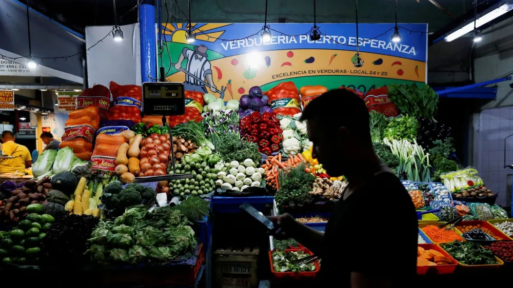 FILE PHOTO: A costumer walks past a greengrocery store, as Argentina's annual inflation rate tore past 100% in February, the country's statistics agency said on Tuesday, the first time it has hit triple figures since a period of hyperinflation in 1991, over three decades ago, in Buenos Aires, Argentina March 14, 2023. REUTERS/Agustin Marcarian/File Photo
