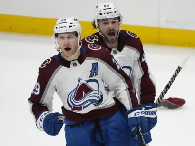 Colorado Avalanche center Nathan MacKinnon (29) celebrates with Samuel Girard (49) after MacKinnon scored against the Nashville Predators during the third period of an NHL hockey game Friday, April 14, 2023, in Nashville, Tenn. The Avalanche won 4-3. (AP Photo/Mark Humphrey)
