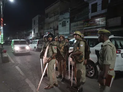 Policemen stand guard the area where gangster-turned-politician Atiq Ahmad and his brother Ashraf were shot, in, Prayagraj, India, Saturday, April 15, 2023. (AP Photo/Rajesh Kumar Singh)