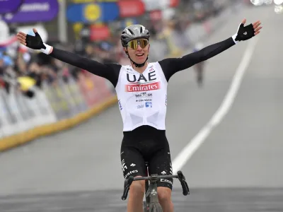 Slovenia's Tadej Pogacar of the UAE Team Emirates celebrates as he crosses the finish line to win the Tour of Flanders in Oudenaarde, Belgium on Sunday, April 2, 2023. (AP Photo/Geert Vanden Wijngaert)