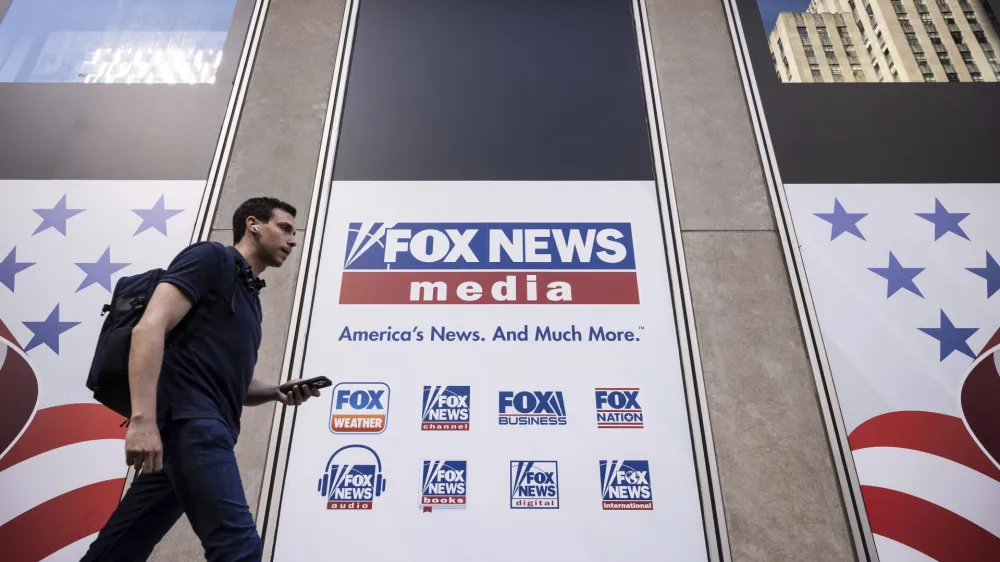 FILE - A person walks past the Fox News Headquarters in New York, Wednesday, April. 12, 2023. Dominion Voting Systems' defamation lawsuit against Fox News for airing bogus allegations of fraud in the 2020 election is set to begin trial on Tuesday, April 18, 2023, in Delaware. (AP Photo/Yuki Iwamura, File)