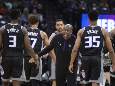 Sacramento Kings coach Mike Brown greets guard Terence Davis (3) and guard PJ Dozier (35) during a timeout in the first half of the team's NBA basketball game against the Golden State Warriors in Sacramento, Calif., Friday, April 7, 2023. (AP Photo/José Luis Villegas)
