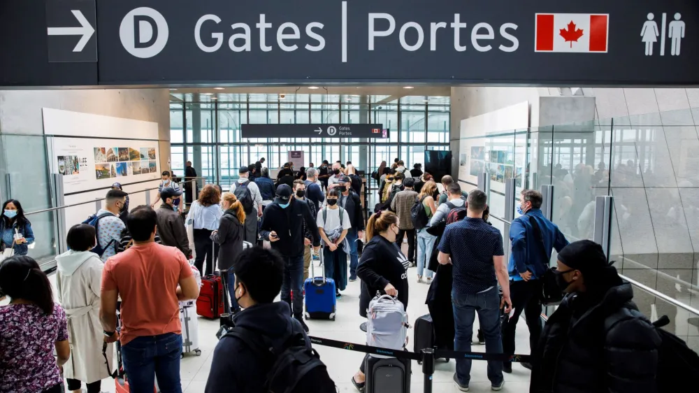 FILE PHOTO: Travellers crowd the security queue in the departures lounge at the start of the Victoria Day holiday long weekend at Toronto Pearson International Airport in Mississauga, Ontario, Canada, May 20, 2022. REUTERS/Cole Burston/File Photo