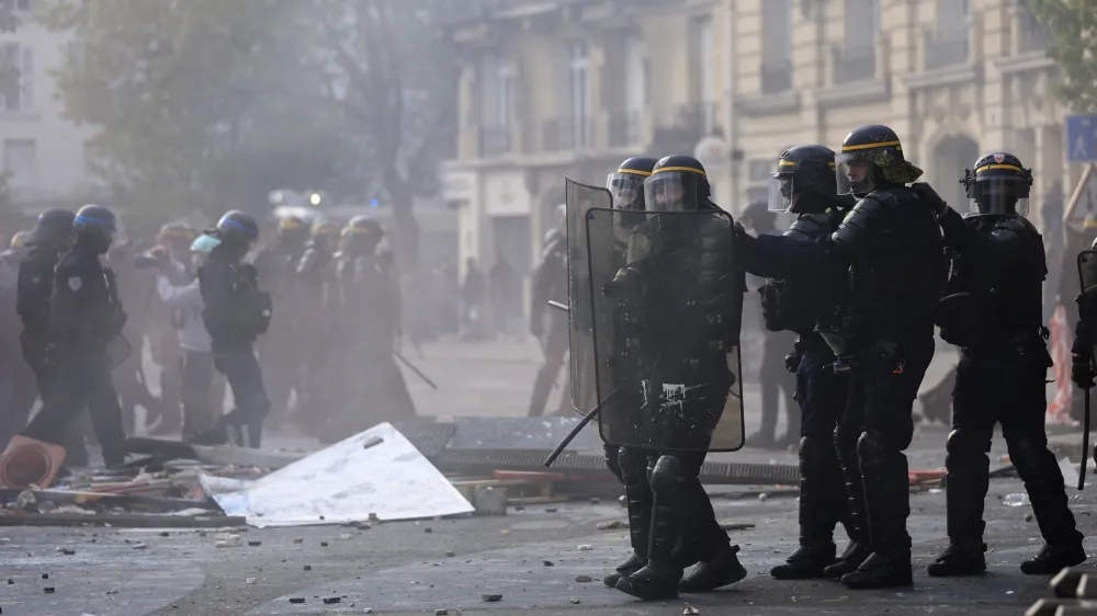 Riot police officers advance among debris during a demonstration, Monday, May 1, 2023 in Paris. Across France, thousands marched in what unions hope are the country's biggest May Day demonstrations in years, mobilized against President Emmanuel Macron's recent move to raise the retirement age from 62 to 64. (AP Photo/Aurelien Morissard)