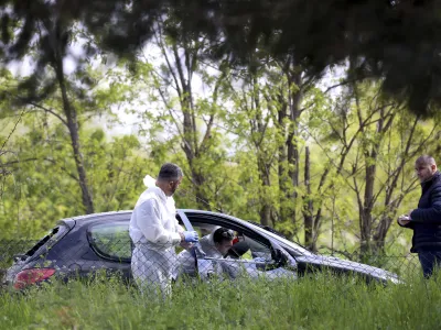 Forensic police operate on a car in the the village of Dubona, some 50 kilometers (30 miles) south of Belgrade, Serbia, Friday, May 5, 2023. A shooter killed multiple people and wounded more in a drive-by attack late Thursday in Serbia's second such mass killing in two days, state television reported. (AP Photo/Armin Durgut)