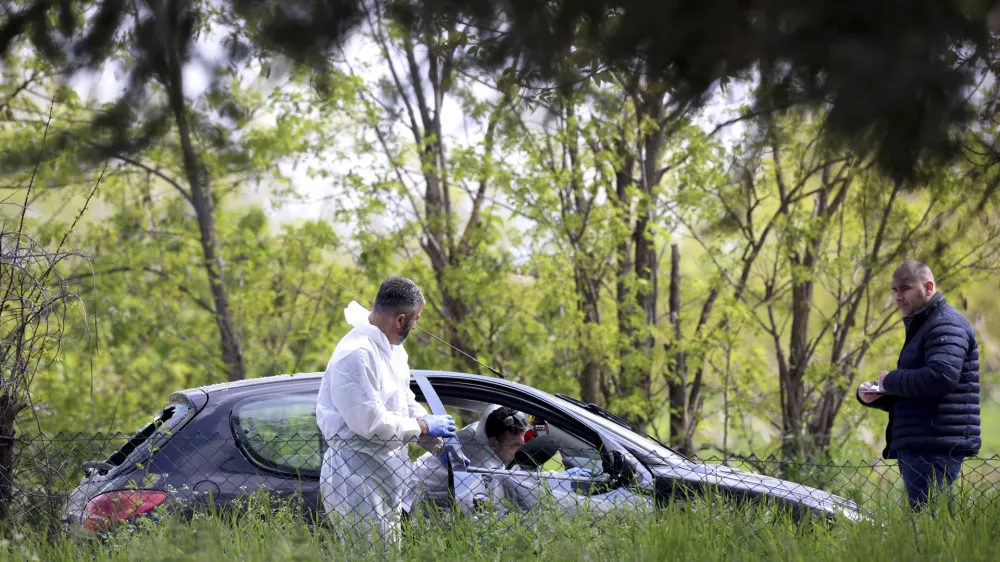 Forensic police operate on a car in the the village of Dubona, some 50 kilometers (30 miles) south of Belgrade, Serbia, Friday, May 5, 2023. A shooter killed multiple people and wounded more in a drive-by attack late Thursday in Serbia's second such mass killing in two days, state television reported. (AP Photo/Armin Durgut)
