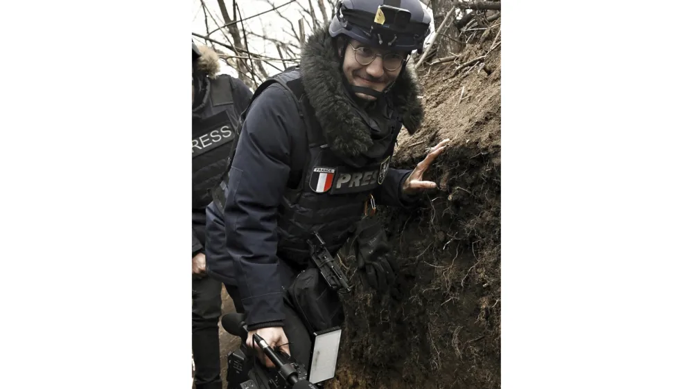 AFP journalist Arman Soldin walks in a trench as he covers the war in Ukraine, March 18, 2023. French international news agency Agence France-Presse says its Ukraine video coordinator Arman Soldin was killed Tuesday, May 9, 2023, during a rocket attack near the eastern Ukrainian city of Bakhmut. French media outlets reported that the late afternoon attack took place in the vicinity of Chasiv Yar, a town near Bakhmut. Russian forces have been trying to capture the city for nine months, making Bakhmut the focus of the war's longest battle. (Aris Messinis/AFP via AP)