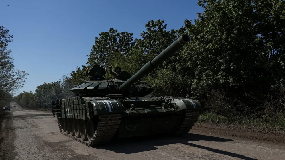 Ukrainian servicemen ride atop of a tank on a road to the frontline town of Bakhmut, amid Russia's attack on Ukraine, in Donetsk region, Ukraine May 12, 2023. REUTERS/Sofiia Gatilova