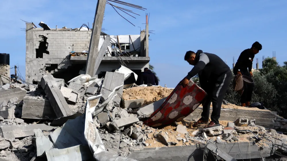 Palestinians salvage belongings from among the rubble of buildings, which were damaged in an Israeli strike during Israel-Gaza fighting, after a ceasefire was agreed between Palestinian factions and Israel, in Deir Al-Balah, central Gaza Strip May 14, 2023. REUTERS/Ibraheem Abu Mustafa