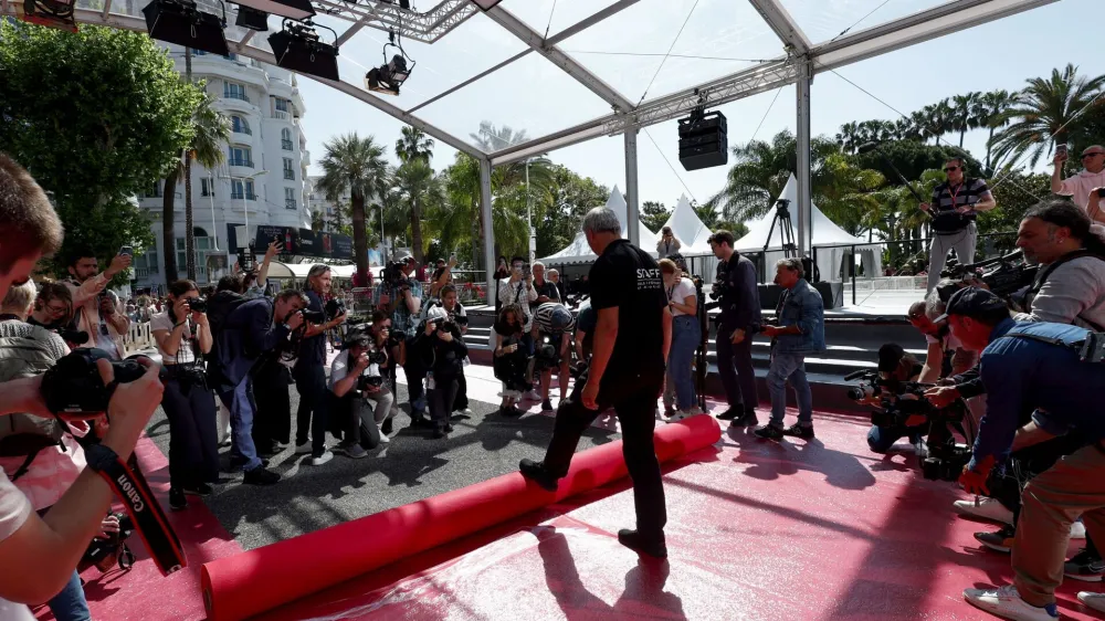 The 76th Cannes Film Festival - Red carpet installation - Cannes, France, May 16, 2023. Photographers take photos as workers install the red carpet in front of the main entrance of the Festival Palace before the opening ceremony. REUTERS/Gonzalo Fuentes