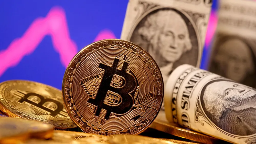 FILE PHOTO: A representation of virtual currency Bitcoin and U.S. One Dollar banknotes are seen in front of a stock graph in this illustration taken January 8, 2021. REUTERS/Dado Ruvic/File Photo