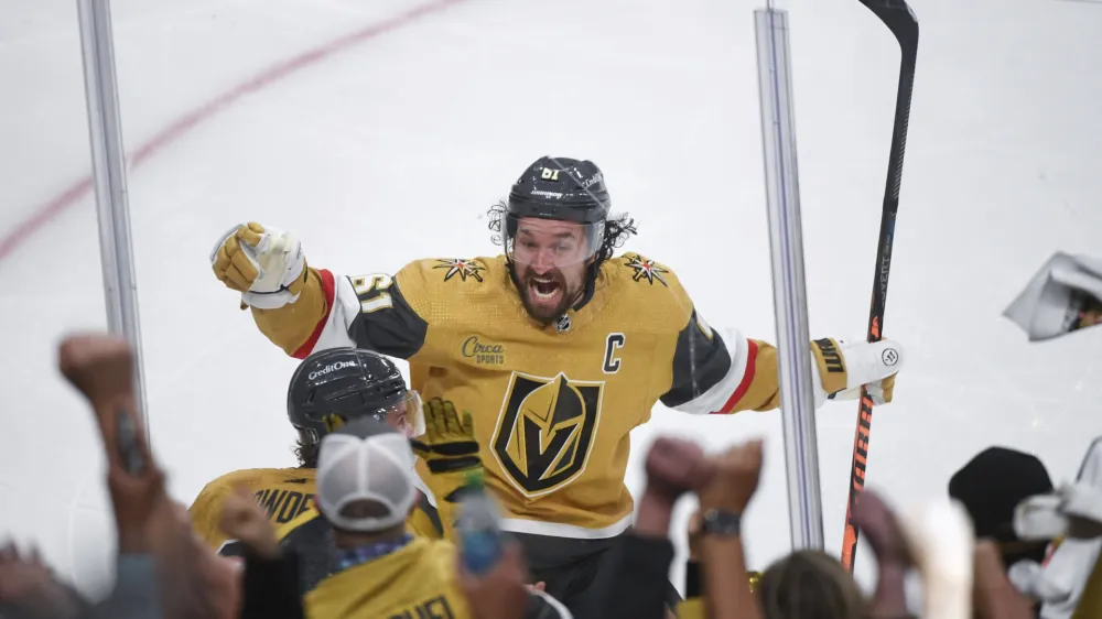 Vegas Golden Knights wing Mark Stone celebrates with Brett Howden, obscured at lower left, who scored in overtime against the Dallas Stars during Game 1 of the NHL hockey Stanley Cup Western Conference finals Friday, May 19, 2023, in Las Vegas. The Golden Knights won 4-3. (AP Photo/Sam Morris)