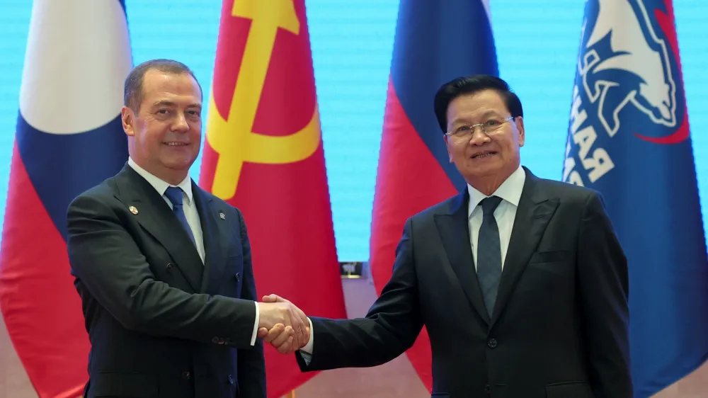 Russian Security Council Deputy Chairman and the head of the United Russia party Dmitry Medvedev, left, and Laos' President Thongloun Sisoulith shake hands during their meeting in Vientiane, Laos, on Tuesday, May 23, 2023. (Ekaterina Shtukina/Pool Sputnik via AP)