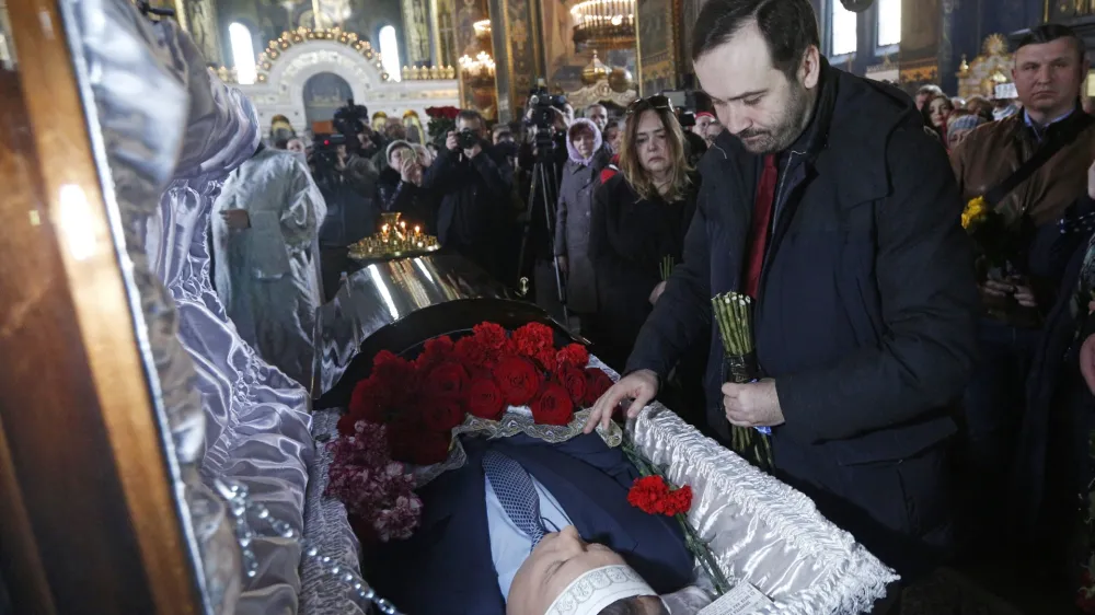 Ilya Ponomarev,a fugitive Russian lawmaker, pays respects for slain former Russian lawmaker Denis Voronenkov during his funeral service, at St. Volodymyr Cathedral in Kiev, Ukraine, Saturday, March 25, 2017. A Ukrainian official said Friday that the killer of Voronenkov, who was gunned down in the Ukrainian capital of Kiev, was a Russian agent, a claim quickly rejected by the Kremlin. (e to Ukraine, was shot dead near the entrance of an upscale hotel in the center of the Ukrainian capital on Thursday. He was wanted on criminal charges in Russia. (AP Photo/Sergei Chuzavkov)