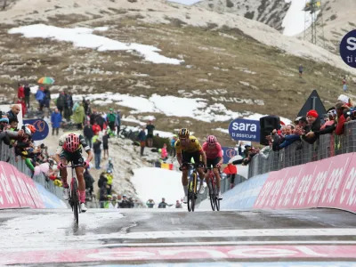 Primož Roglič (v sredini) je tik pred ciljno črto današnje etape ukradel tri sekunde nosilcu rožnate majice, Valižanu Geraintu Thomasu (desno).