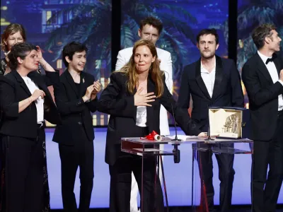 Director Justine Triet, Palme d'Or award winner for the film "Anatomie d'une chute" (Anatomy of a Fall), reacts next to team on stage during the closing ceremony of the 76th Cannes Film Festival in Cannes, France, May 27, 2023. REUTERS/Eric Gaillard