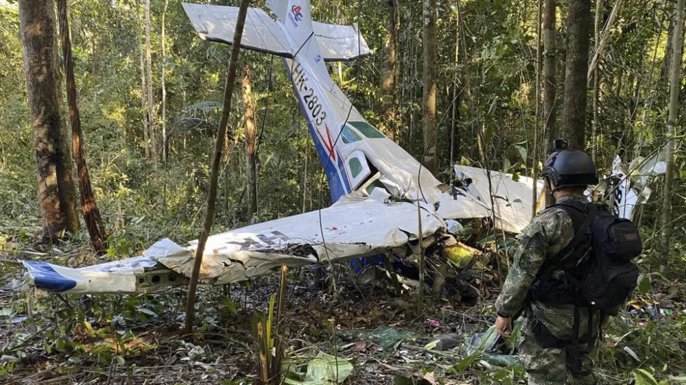 FILE - In this photo released by Colombia's Armed Forces Press Office, a soldier stands in front of the wreckage of a Cessna C206, May 18, 2023, that crashed in the jungle of Solano in the Caqueta state of Colombia. The discovery of footprints on May 30 of a small foot rekindled the hope of finding the children alive after their plane crashed on May 1. Soldiers found the wreckage and the bodies of three adults, including the pilot and the children's mother. (Colombia's Armed Forces Press Office via AP, File)