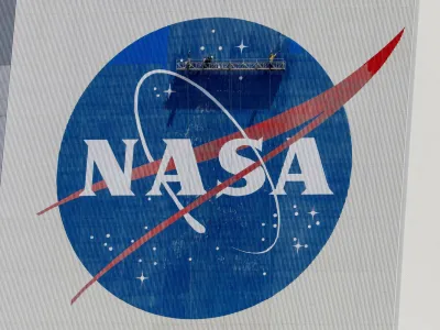 FILE PHOTO: Workers pressure wash the logo of NASA on the Vehicle Assembly Building before SpaceX will send two NASA astronauts to the International Space Station aboard its Falcon 9 rocket, at the Kennedy Space Center in Cape Canaveral, Florida, U.S., May 19, 2020. REUTERS/Joe Skipper/File Photo