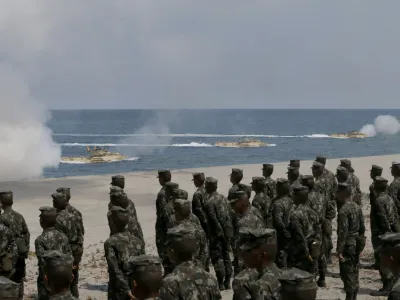 ﻿Philippine Marines watch U.S. Navy amphibious assault vehicles storm the beach during a combined assault exercise facing one of the contested islands in the South China Sea known as the Scarborough Shoal in the West Philippine Sea Tuesday, April 21, 2015 at the Naval Education and Training Command at San Antonio township, Zambales province, northwest of Manila, Philippines. More than ten thousand troops from both the U.S. and Philippine militaries are taking part in the annual military drill that focuses on regional security, terrorism, disaster preparedness and inter-operability of both countries. (AP Photo/Bullit Marquez)