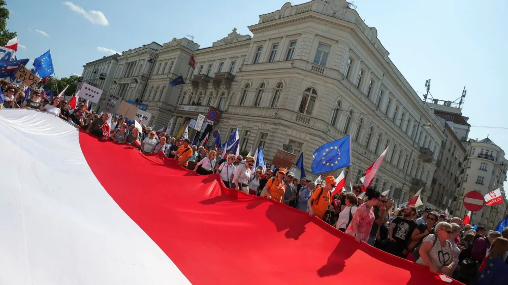 People carry a giant Polish flag during a march on the 34th anniversary of the first democratic elections in postwar Poland, in Warsaw, Poland, June 4, 2023. REUTERS/Kacper Pempel
