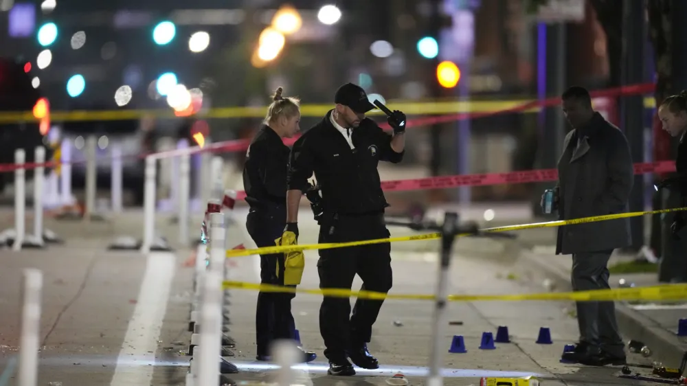 Denver Police Department investigators work the scene of a mass shooting along Market Street between 20th and 21st avenues during a celebration after the Denver Nuggets won the team's first NBA Championship early Tuesday, June 13, 2023, in Denver. (AP Photo/David Zalubowski)