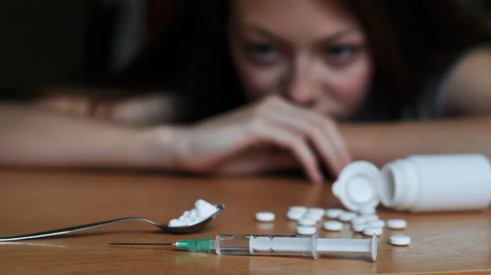 ﻿Junkie girl looking at drugs