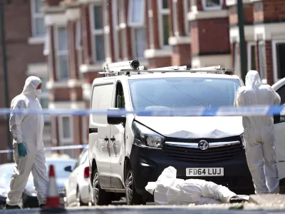 Police forensics officers search a white van on the corner of Maples Street and Bentinck Road in Nottingham, as three people have been found dead in the city in what police described as a "horrific and tragic incident". A 31-year-old man has been arrested on suspicion of murder after two people were found dead in the street in Ilkeston Road just after 4am on Tuesday. A third man was found dead in Magdala Road, Nottinghamshire Police said. Another three people are in hospital after someone tried to run them over in a van in Milton Street, in what police believe was a connected incident, Tuesday June 13, 2023. (Zac Goodwin/PA via AP)