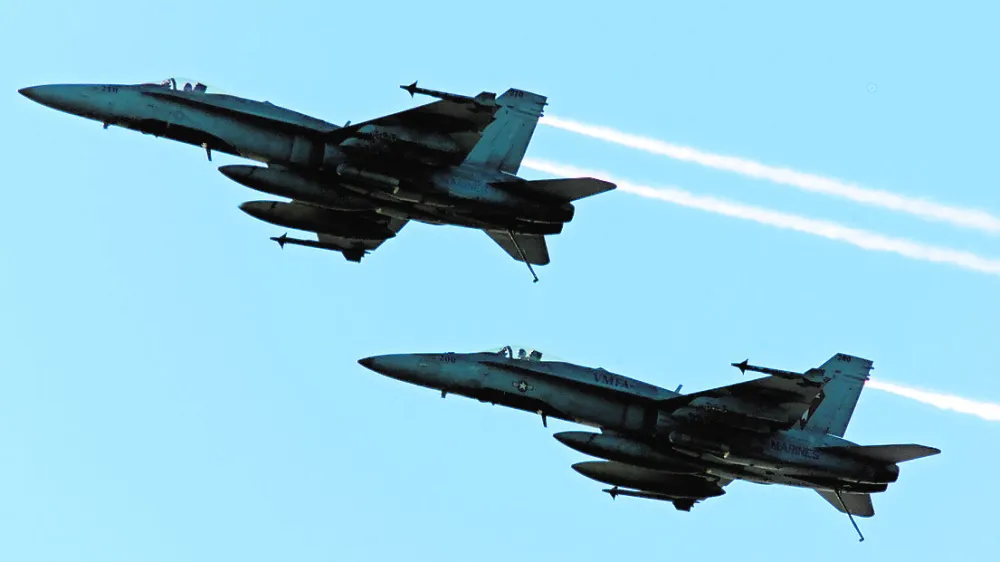 A pair of F/18C Hornets circle the USS Theodore Roosevelt after flying a mission over Afghanistan Tuesday, Dec. 11, 2001 aboard the USS Theodore Roosevelt in the Arabian Sea. War planes from the ship are continuing bombing missions in Afghanistan as fighting around the Tora Bora area where Osama Bin Laden is believed to be hiding intensifies.(AP Photo/Ed Wray, Pool)