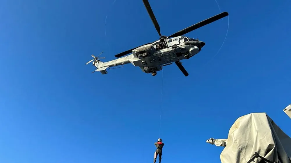 A undated handout photo provided by the Hellenic Coast Guard shows a helicopter during a rescue operation to save migrants onboard a boat, before it capsized at open sea, off Greece. Hellenic Coast Guard/Handout via REUTERS ATTENTION EDITORS - THIS IMAGE HAS BEEN SUPPLIED BY A THIRD PARTY.