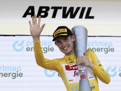 Denmark's Mattias Skjelmose holds the trophy as he celebrates on the podium after winning the Tour de Suisse, during the eighth and final stage, a 25,7 km individual time trial, from St. Gallen to Abtwil, at the 86th Tour de Suisse cycling race, in Abtwil, Sunday, June 18, 2023. (Gian Ehrenzeller/Keystone via AP)