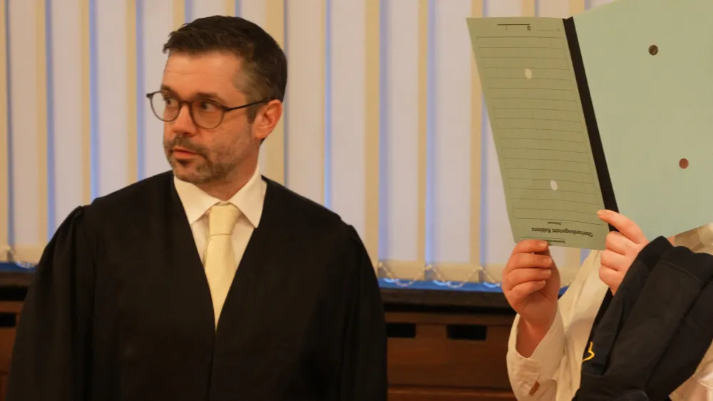 FILED - 11 January 2023, Rheinland-Pfalz, Koblenz: The 37-year-old defendant (R) stands next to one of her lawyers in the courtroom of the Higher Regional Court. A German woman was convicted on Wednesday of membership of the Islamic State terrorist organization, crimes against humanity and aiding and abetting genocide. Photo: Thomas Frey/dpa - ACHTUNG: Die Angeklagte wurde auf Anweisung des Gerichts gepixelt