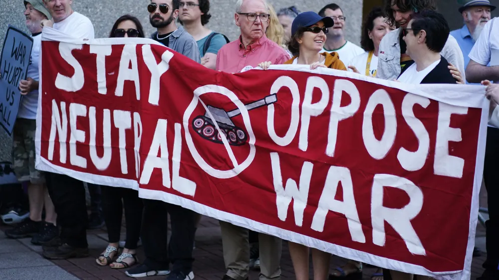 22 June 2023, Ireland, Cork: Protesters at University College Cork hold a banner during a protest ahead of the Consultative Forum on International Security Policy. Photo: Brian Lawless/PA Wire/dpa