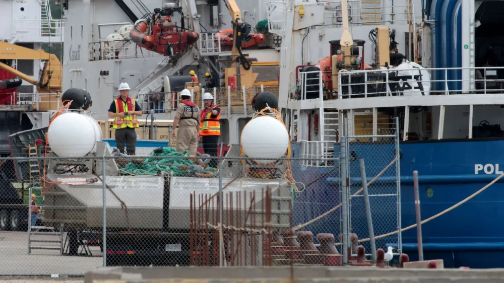 People inspect the Polar Prince ship and the deployment barge, used with the Titan submersible that imploded while carrying five people to explore the wreck of the sunken Titanic, as the Transportation Safety Board of Canada begins its investigation into the loss of the submersible from OceanGate Expeditions, at St. John's harbour, Newfoundland, Canada June 25, 2023. REUTERS/David Hiscock NO RESALES. NO ARCHIVES