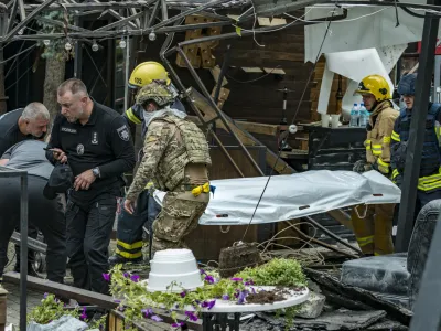 28 June 2023, Ukraine, Kramatorsk: Members of a rescue unit carry a victim killed when a Russian missile hit the center of the city of Kramatorsk. At least eleven people were killed in the Russian missile attack on a popular pub in the eastern Ukrainian city of Kramatorsk. Photo: Celestino Arce Lavin/ZUMA Press Wire/dpa