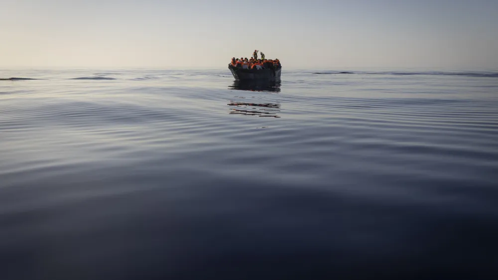 FILE - Migrants with life jackets provided by volunteers of the Ocean Viking, a migrant search and rescue ship run by NGOs SOS Mediterranee and the International Federation of Red Cross (IFCR), still sail in a wooden boat as they are being rescued, on Aug. 27, 2022. The border and coast guard agency Frontex estimated that more than 50,300 attempts were made to enter the EU without authorization from January to May. It's more than double the number in the same period last year, and the most since 2017. (AP Photo/Jeremias Gonzalez, File)