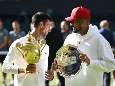 FILE PHOTO: Tennis - Wimbledon - All England Lawn Tennis and Croquet Club, London, Britain - July 10, 2022 Serbia's Novak Djokovic poses with the trophy after winning the men's singles final alongside runner up Australia's Nick Kyrgios REUTERS/Toby Melville/File Photo