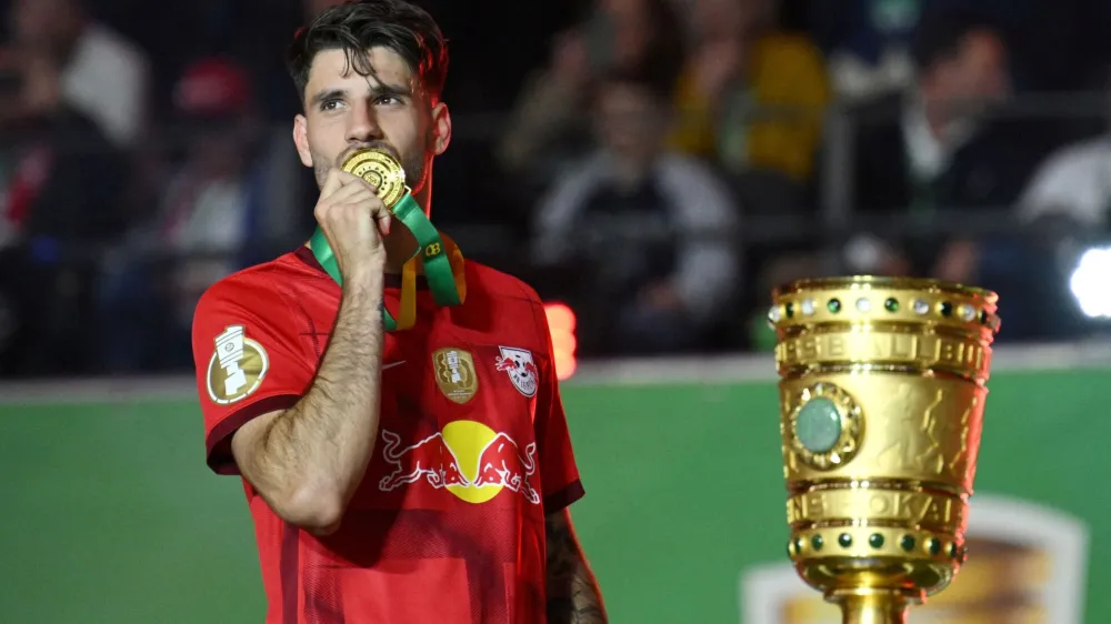 FILE PHOTO: Soccer Football - DFB Cup - Final - RB Leipzig v Eintracht Frankfurt - Olympiastadion, Berlin, Germany - June 3, 2023 RB Leipzig's Dominik Szoboszlai kisses his medal as he celebrates after winning the DFB Cup REUTERS/Annegret Hilse DFB REGULATIONS PROHIBIT ANY USE OF PHOTOGRAPHS AS IMAGE SEQUENCES AND/OR QUASI-VIDEO./File Photo