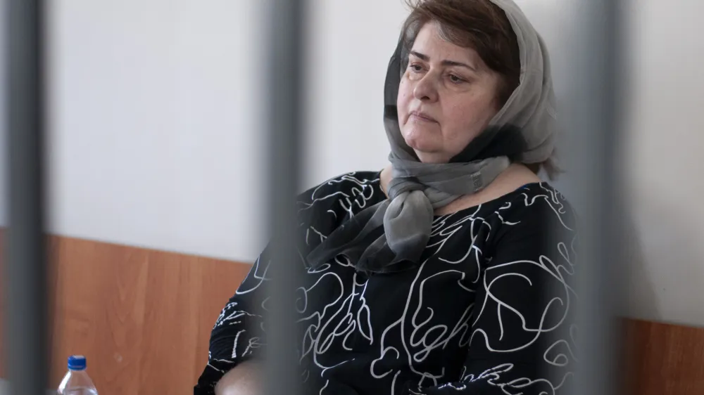 Zarema Musayev sits behind bars in a courtroom a in Grozny, Russia, Tuesday, July 4, 2023. Musayev is the mother of two local activists who have challenged Chechen authorities and has been in custody in Chechnya since her arrest in January 2022. Unidentified masked assailants in the Russian province of Chechnya attacked and beat Novaya Gazeta journalist Elena Milashina and lawyer Alexander Nemov on Tuesday, who had just arrived in Chechnya to attend the trial of Musayeva. (AP Photo)