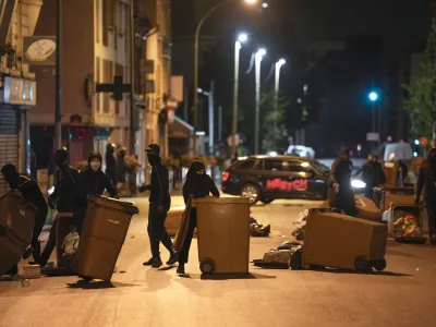 Protesters block a street with garbage cans in Colombes, outside Paris, France, Saturday, July 1, 2023. French President Emmanuel Macron urged parents Friday to keep teenagers at home and proposed restrictions on social media to quell rioting spreading across France over the fatal police shooting of a 17-year-old driver. (AP Photo/Lewis Joly)