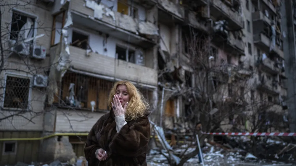 FILE - Natali Sevriukova reacts next to her house following a rocket attack the city of Kyiv, Ukraine, on Feb. 25, 2022. With Russia's war on Ukraine in its 17th month and Western countries sending increasingly hi-tech and long-range weapons and ammunition to help President Volodymyr Zelenskyy defend his country, it's easy to lose track of where NATO stands. (AP Photo/Emilio Morenatti, File)