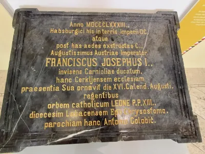 Plo&scaron;ča iz črnega marmorja, shranjena v zakristiji cerkve v Cerkljah, na katero so jo vzidali v spomin na cesarjev obisk.
